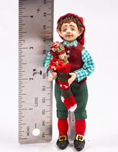 Load image into Gallery viewer, Christmas Elf Porcelain Doll in Checkered Shirt Holding Knitted Stocking Filled with Toys Artisan Made Debra Hammond
