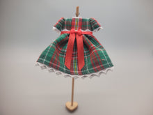 Load image into Gallery viewer, Green and Red Plaid Dress with Red Bow on Wooden Display – by Cheryl Warder
