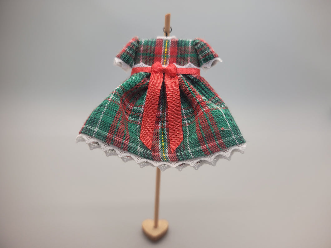 Green and Red Plaid Dress with Red Bow on Wooden Display – by Cheryl Warder